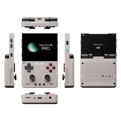 A compact handheld gaming console shown from multiple angles on a plain white background. The front view shows a black display screen with the text 'TRINKET & BRICK PRO', gray controls, and pink buttons.